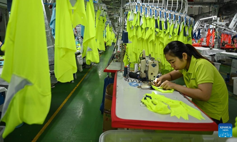 A staff member works on a production line in the manufacturer of the Spanish sports brand Kelme in Jinjiang City, southeast China's Fujian Province, May 13, 2022.Photo:Xinhua